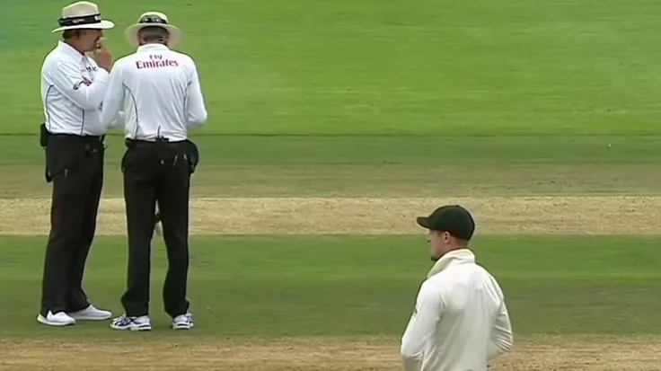 The umpires inspect the ball as Cameron Bancroft looks on