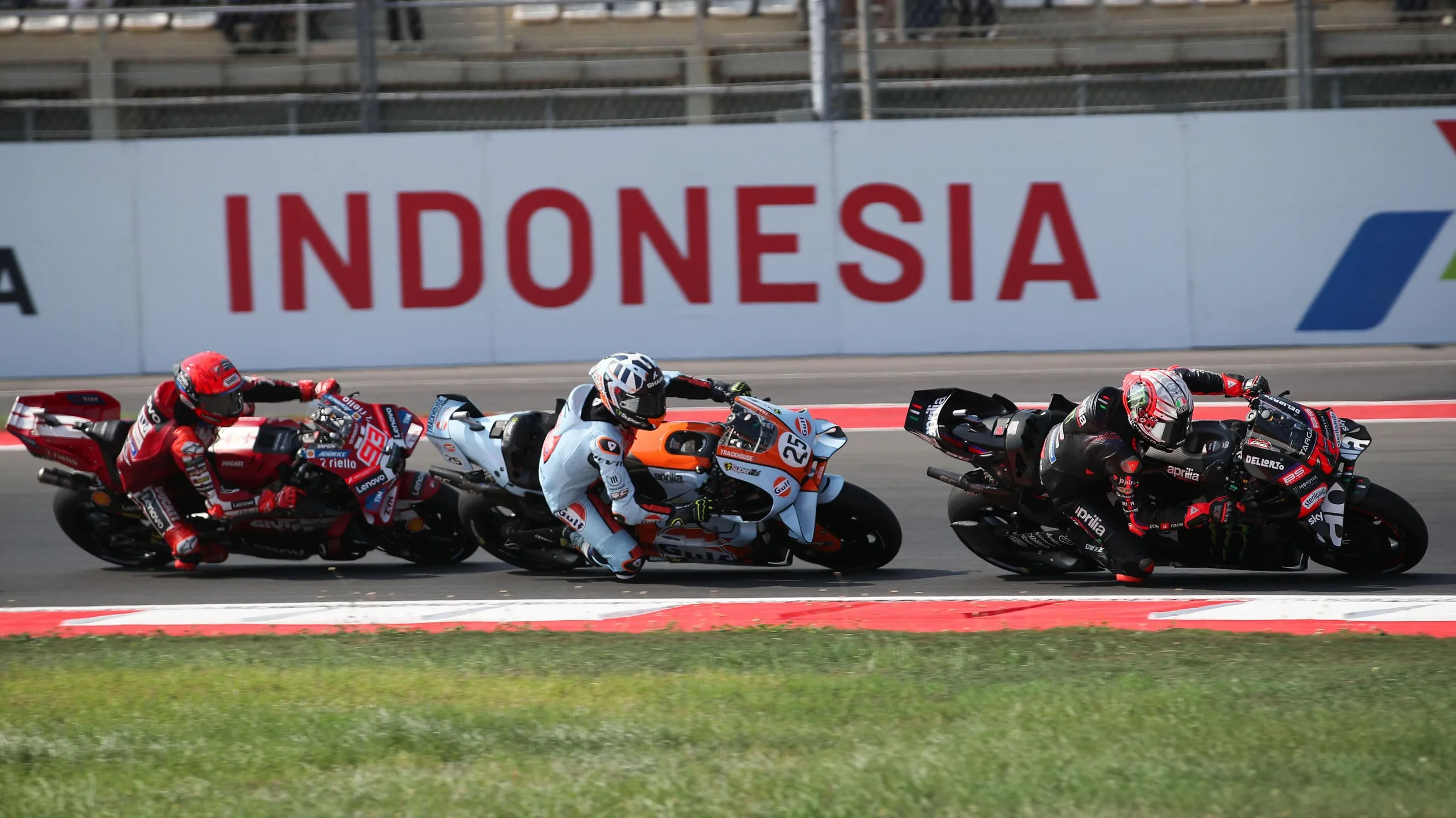 Three riders, including Marco Bezzecchi, take a corner at the Indonesian Grand Prix