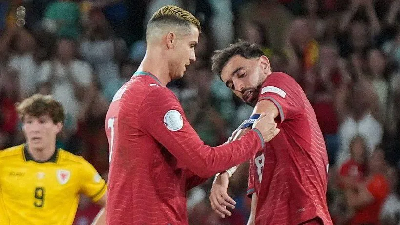 Cristiano Ronaldo handing the Portugal captain's armband to Bruno Fernandes