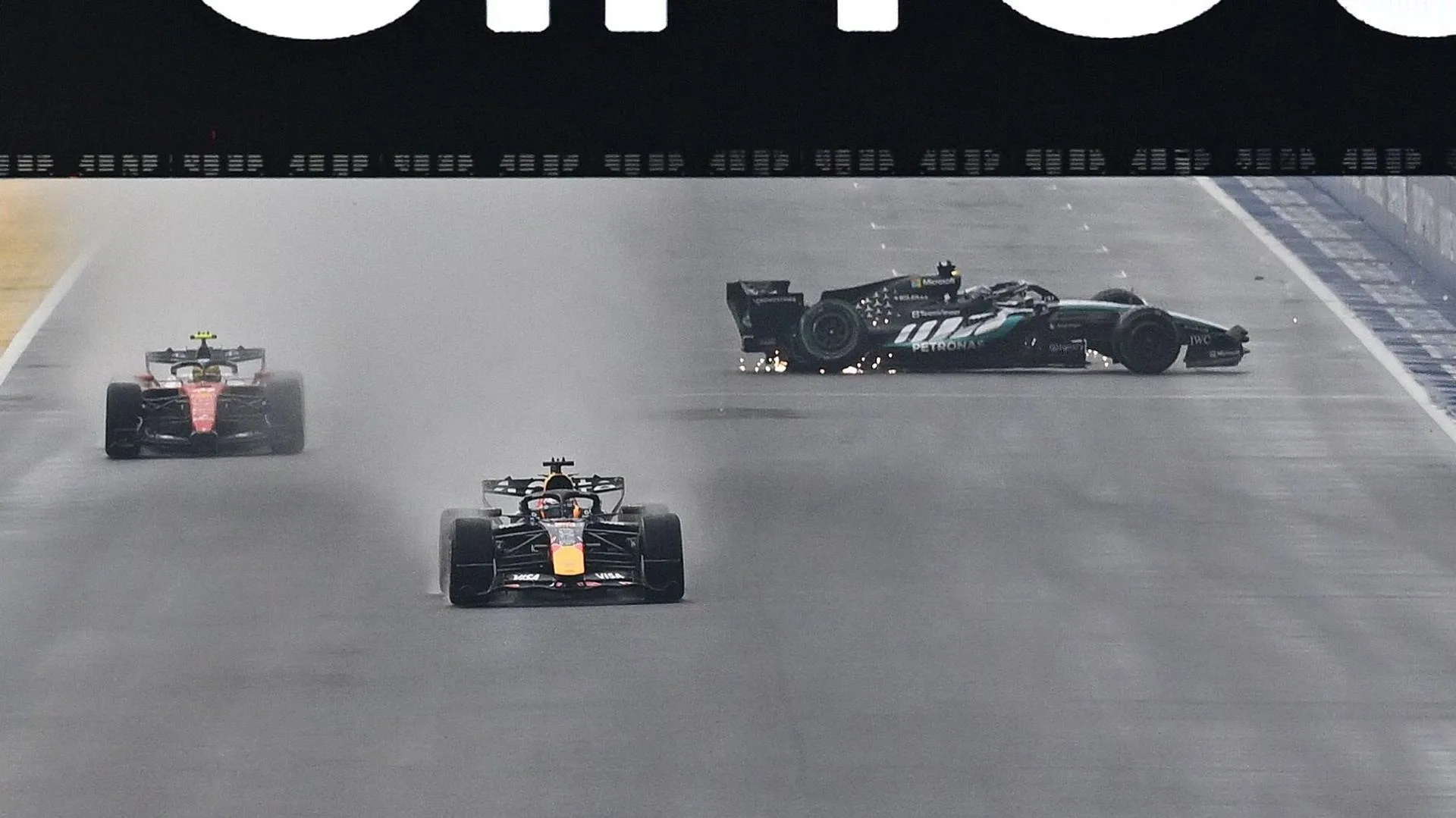 The Mercedes of George Russell spins on the start-finish straight as Red Bull's Max Verstappen and Ferrari's Lewis Hamilton go past during the Singapore Grand Prix sprint race