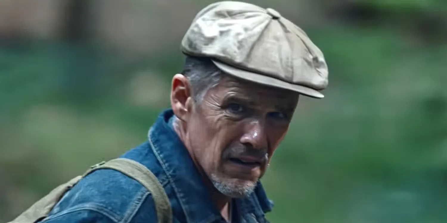 Ethan Hawke wearing a hat outside and squinting in The Weight