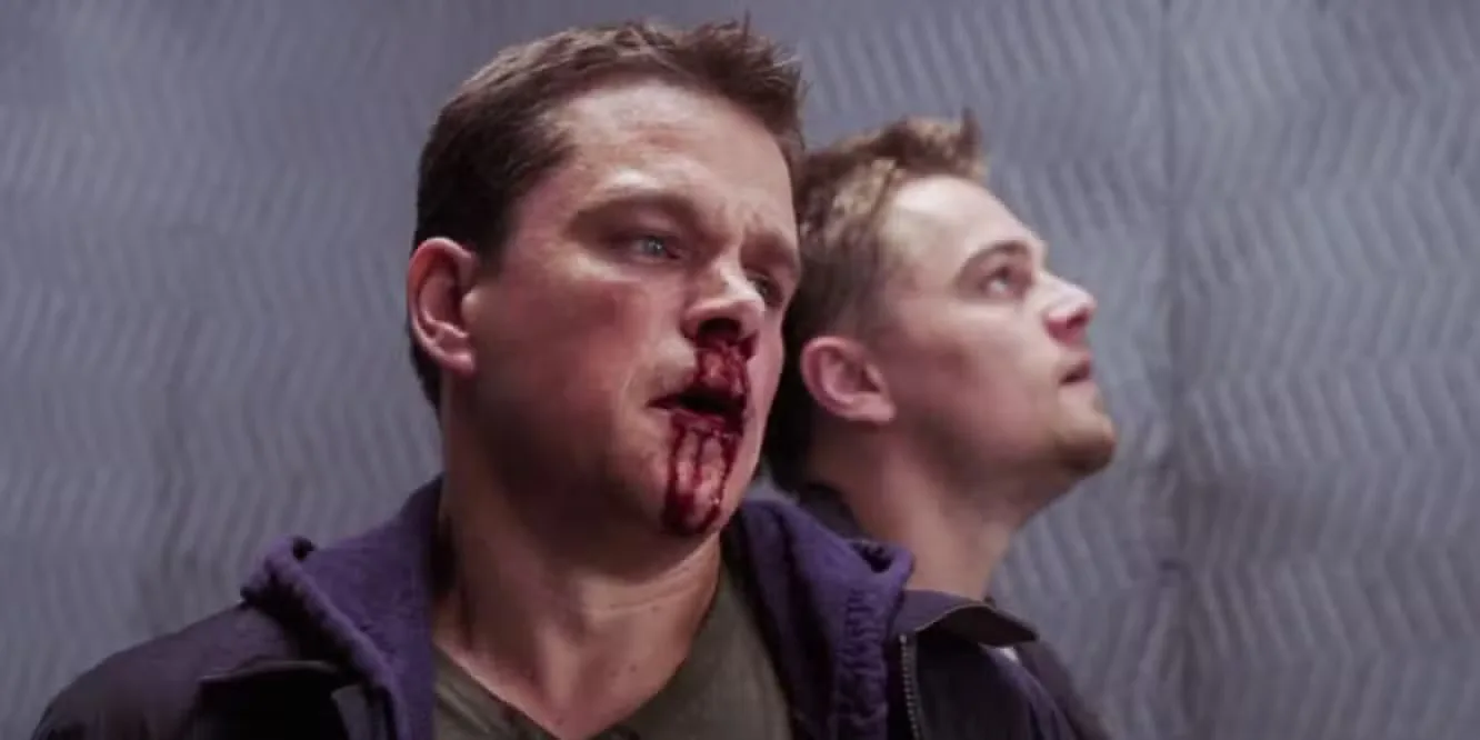 Matt Damon with a bloody nose stands next to Leonardo DiCaprio in an elevator in The Departed.