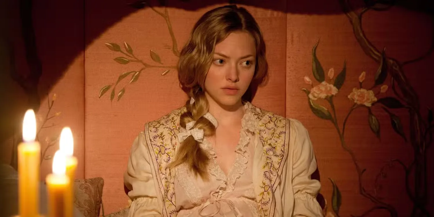 Amanda Seyfried as Cosette leaning against the wall and looking pensive in Les Misérables.