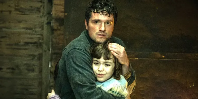 Josh Hutcherson as Mike and Piper Rubio as Abby holding on to each other in fear in Five Nights at Freddy's. 