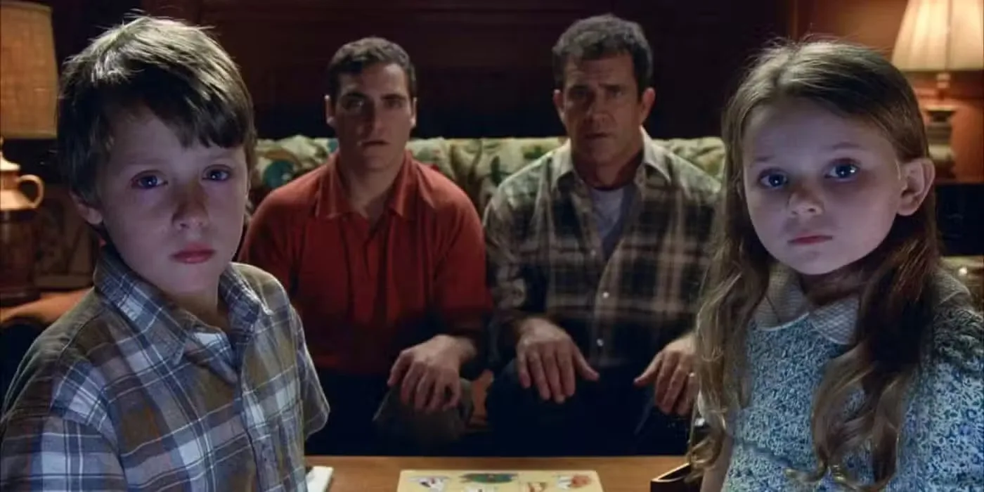 Morgan, Merril, Graham, and Bo Hess looking straight at the camera with serious expressions in Signs.