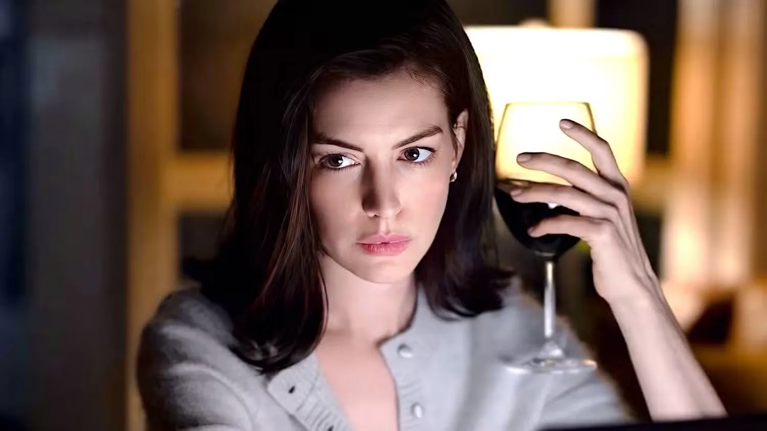 Anne Hathaway clutching a glass of red wine in 'Verity'
