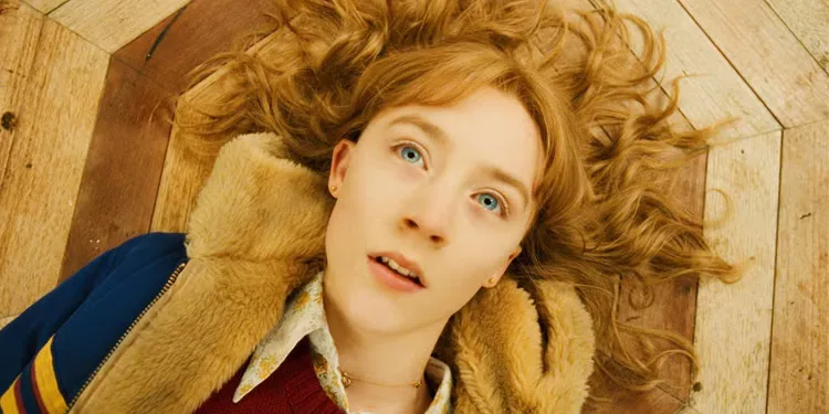 Saoirse Ronan as Susie Salmon, lying on the ground with her hair fanned out around her, staring upwards in The Lovely Bones