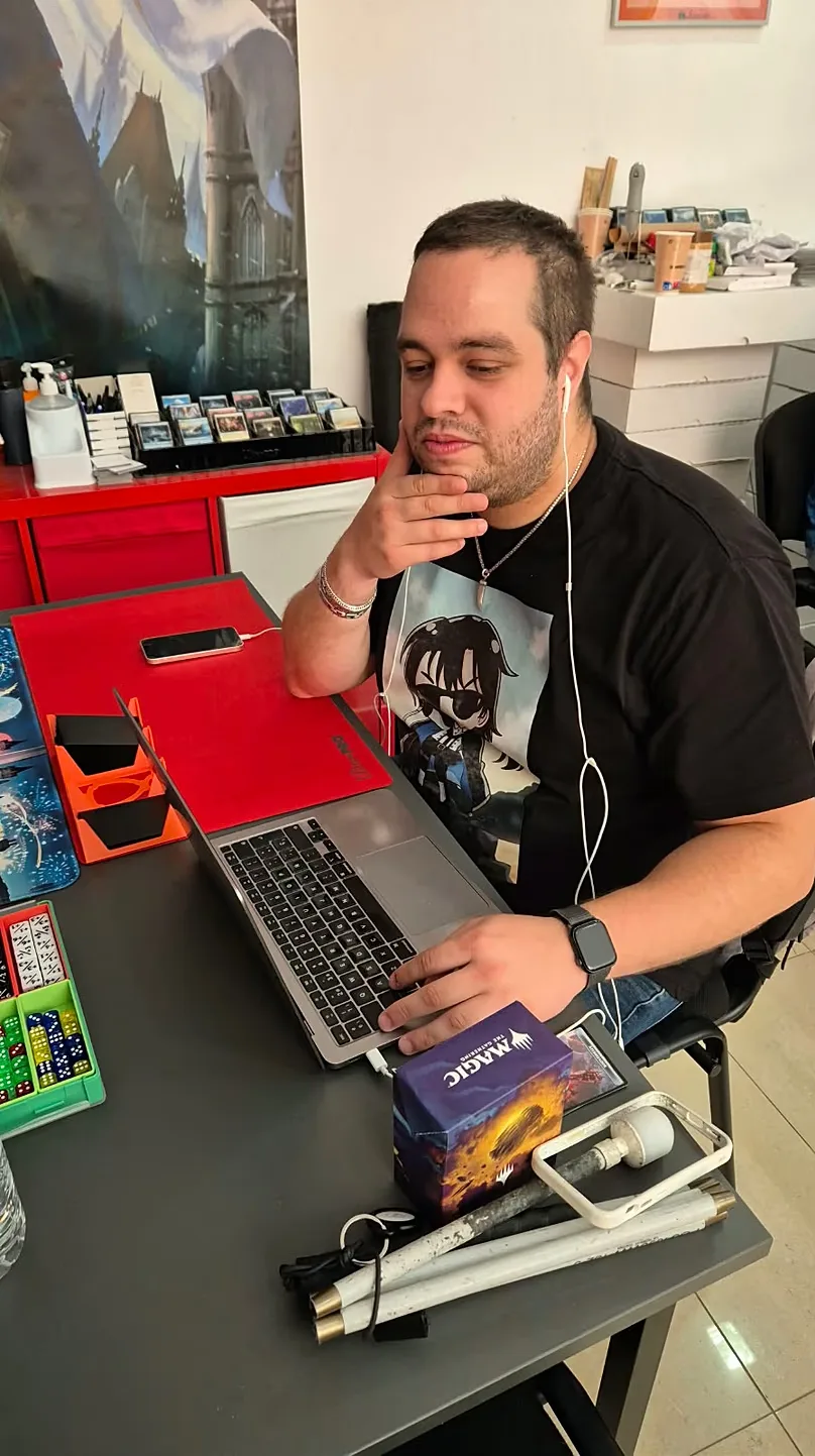 Cristian, with his computer and his white cane during a tournament