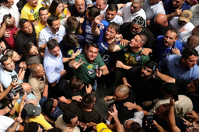 Opposition presidential candidate Sen. Flavio Bolsonaro, center, wearing a green shirt and looking up, campaigns in Sao Paulo, Brazil, Monday, 28 September2026.