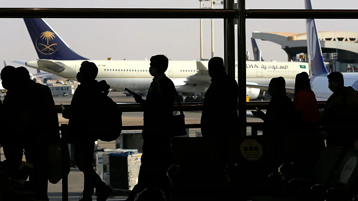 FILE - Passengers line up to check in for their flight at King Khalid Airport in Riyadh, Saudi Arabia, Monday, Jan. 11, 2021.