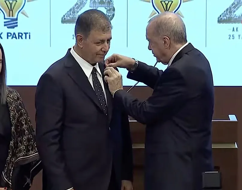 President Erdoğan pinning the party badge on İzmir Metropolitan Mayor Cemil Tugay. 