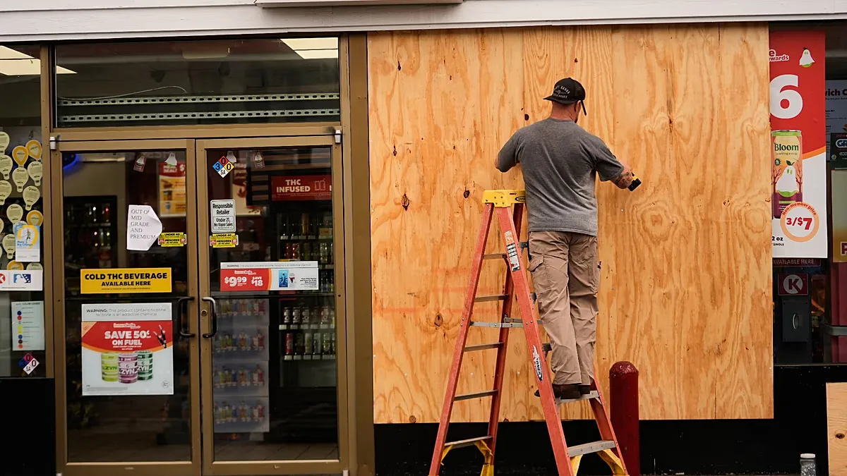 Jason Coffey boards up a convenience store at a gas station as Hurricane Isaias approaches Pensacola Beach, Fla., Friday, Oct. 9, 2026.