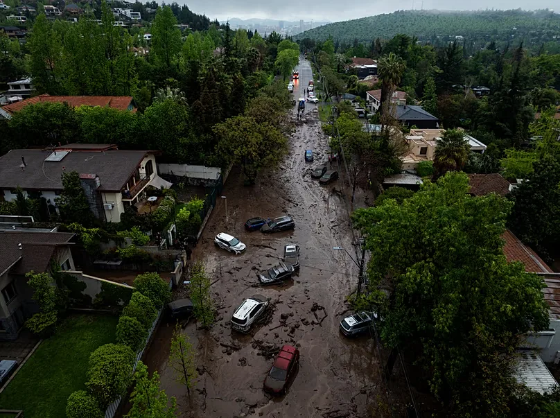 Vehicles are partially inundated in muddy floodwaters after heavy rains caused flash flooding in the Las Condes district of Santiago, Chile, Thursday, Oct. 8, 2026