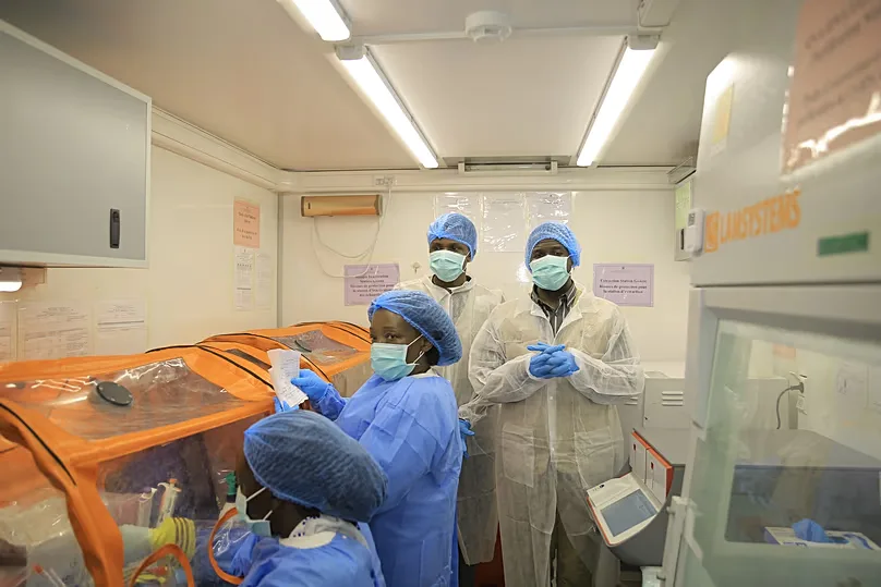 Medical workers work inside a mobile lab set up to test rapidly for Ebola virus in Butembo, DR Congo.