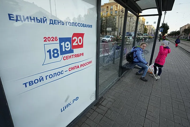 On Monday 14 September 2026 in Saint Petersburg, people wait for a tram at a stop next to a billboard urging them to vote in the three-day parliamentary elections