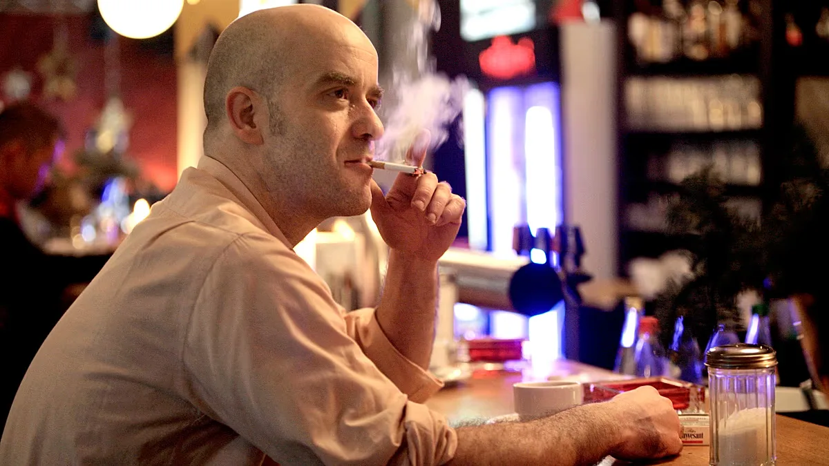 Bar owner Taco smokes a cigarette