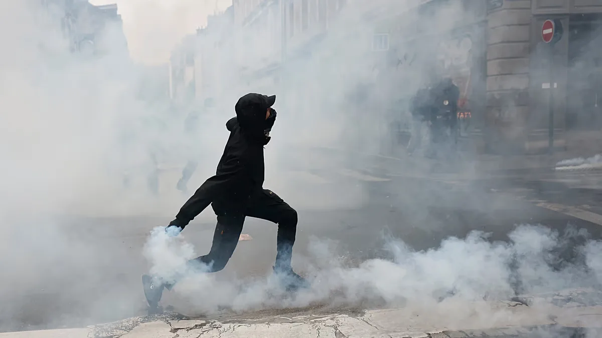 A protester throws a teargas canister to police after a demonstration against rising living costs in Rennes, France, Saturday, Oct. 24, 2026.