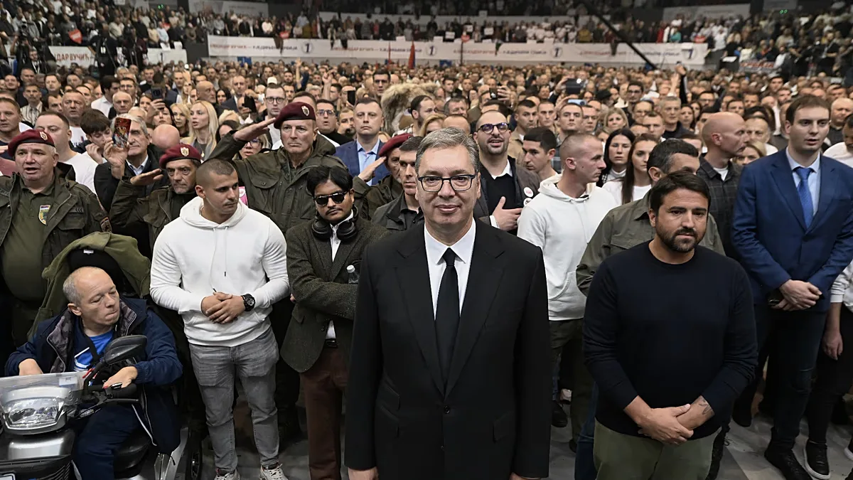 Serbia's populist leader Aleksandar Vucic, center, listens to the Serbian national anthem with supporters during a pre-election rally.