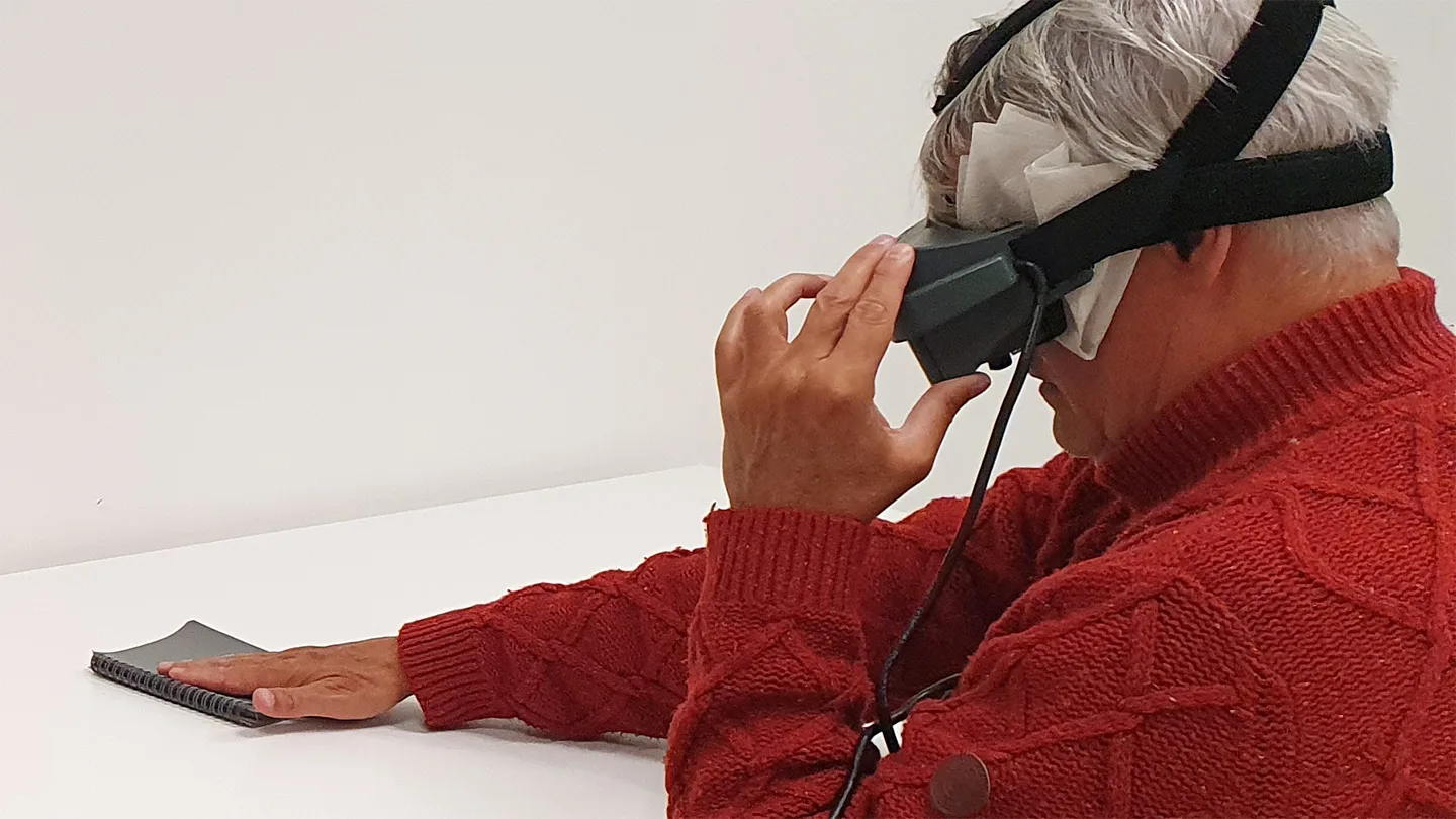 Study participant who is blind reaches for notebook using special googles